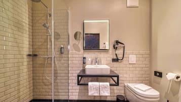 Een moderne badkamer met douche, toilet en wastafel.