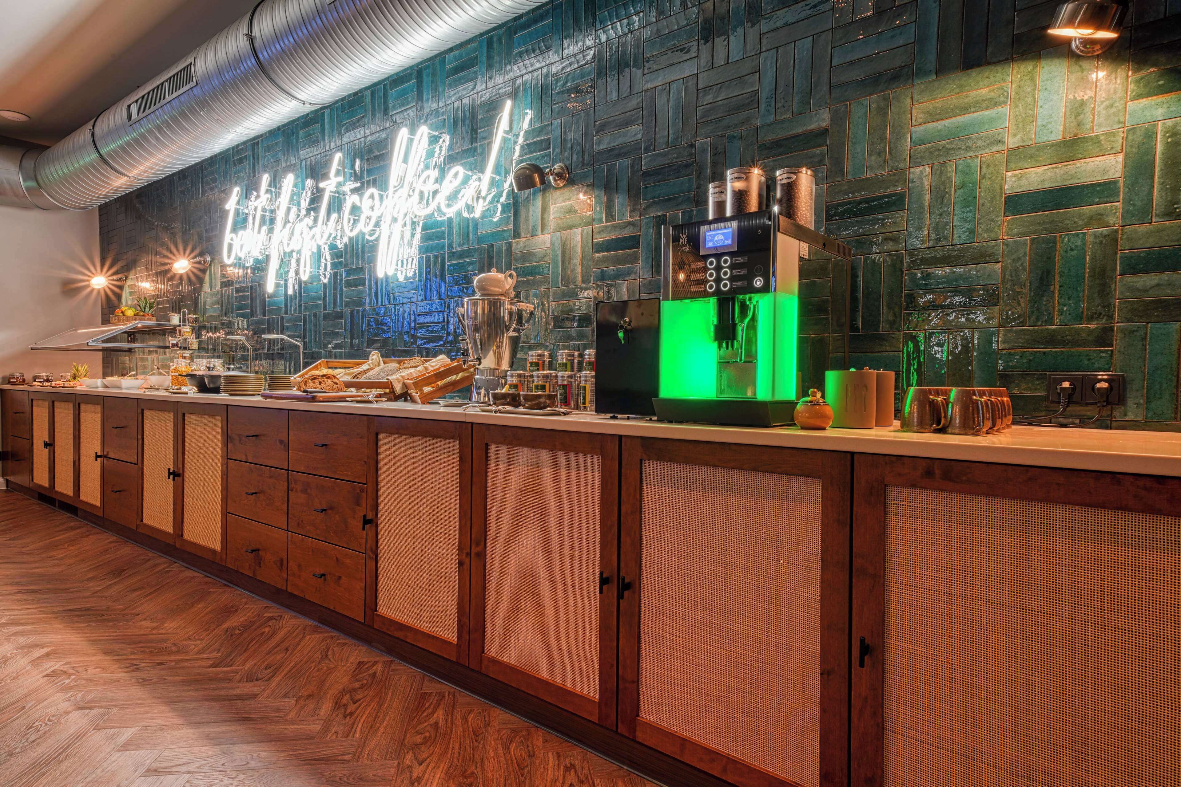 A modern kitchen with a herringbone wood floor, a neon sign reading "Happy Coffee!", and a coffee machine.