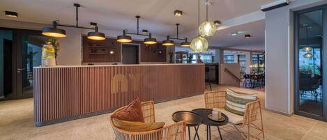 A modern interior with a reception desk, wicker chairs, and a dining area.