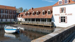 A waterfront hotel with a traditional European architectural style, featuring a prominent balcony and a sign reading "HOTEL DE LA PLAGE". - Hotel de la Plage (Wissant)