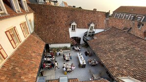 A courtyard with outdoor seating, a small white building, and a tiled roof. - Hotel de la Plage (Wissant)