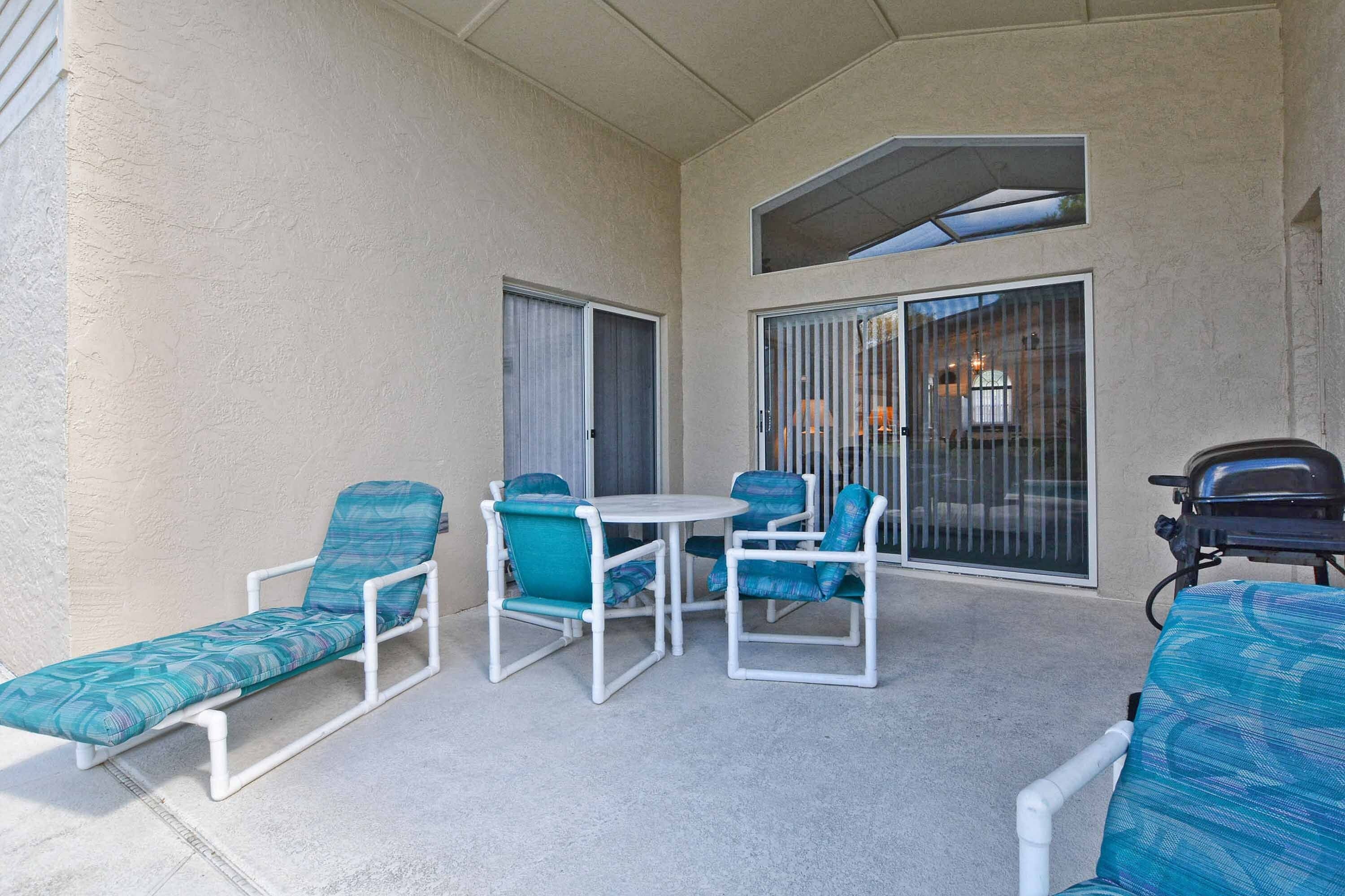 Un espace extérieur abrité, aménagé avec des fauteuils et une table.