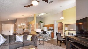 A modern living room with a sofa, coffee table, and TV stand. - Emerald 4 bedrooms with Pool - 2201Em 4 Home by RedAwning (Kissimmee)