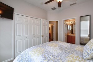 A bedroom with a bed, a wardrobe, a mirror, and a ceiling fan. - Emerald 4 bedrooms with Pool - 2201Em 4 Home by RedAwning (Kissimmee)
