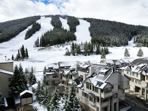 A ski resort with multiple buildings, including a large lodge with a ski lift in the background. - Pet Friendly, Slope-side, Spacious Town Home - ER21 by Redawning (Copper Mountain)