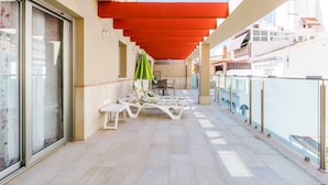 A covered outdoor area with white lounge chairs and a red canopy. - A&n La Cueva 1 . (Torre del Mar)