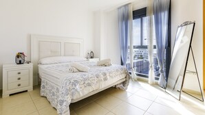 A bedroom with a bed, a nightstand, a window with curtains, and a balcony. - A&N La Vega 6, (Torre del Mar)