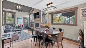 Un vaste espace de vie doté d’une cheminée, d’une table à manger et de sièges confortables.