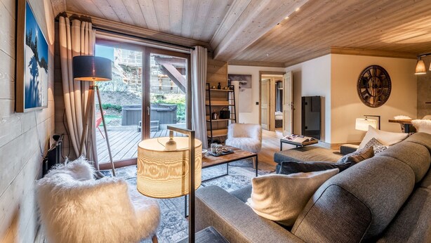 A cozy living room with a wooden ceiling, a sofa, a coffee table, and a lamp. - PADOUK- Apartment w/ hot tub in Courchevel Moriond (Courchevel)