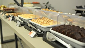 Un bufé con diversos alimentos en recipientes transparentes.