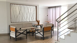 Una sala moderna con sofá, mesa de centro y un elemento decorativo en la pared.