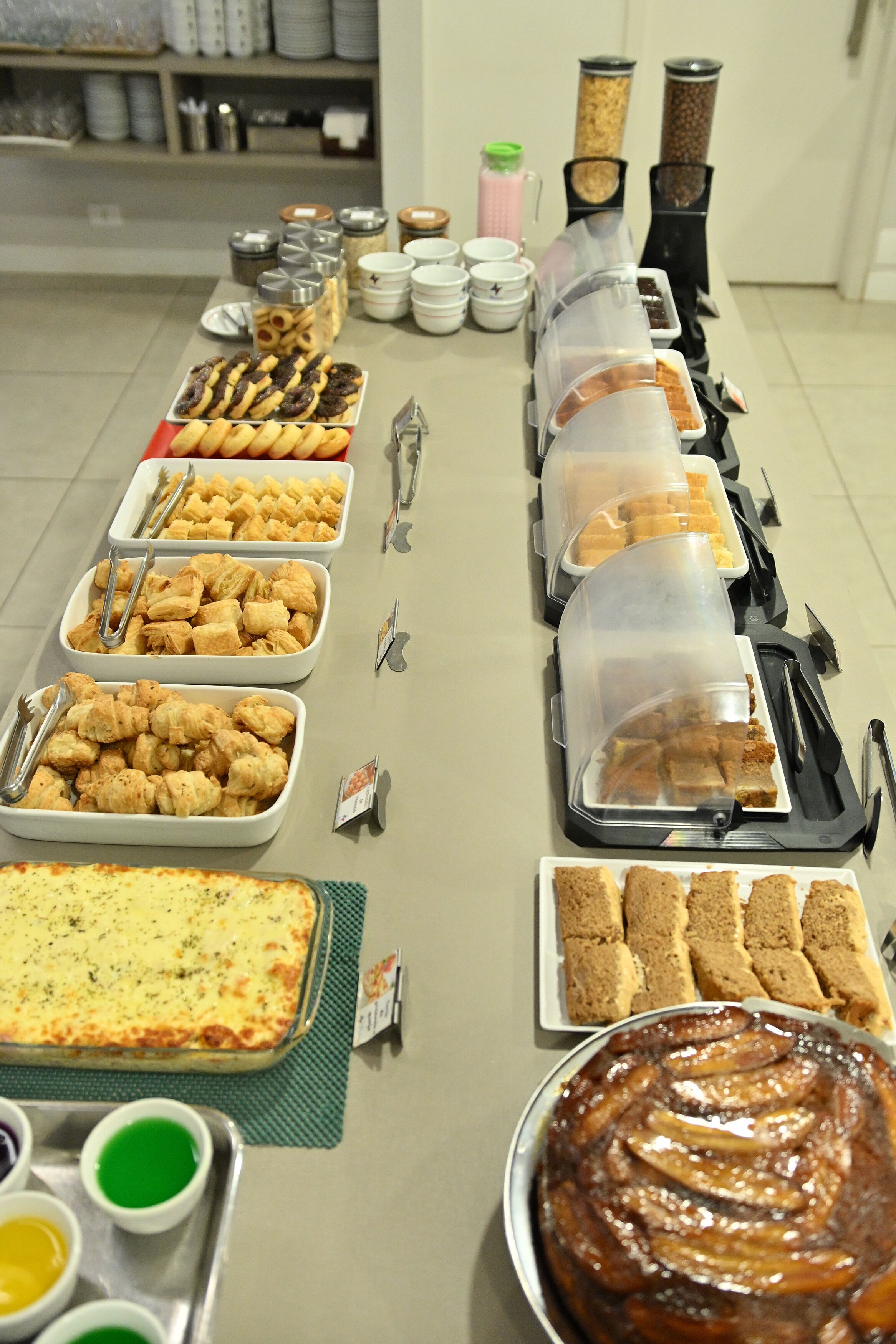 A buffet table with various food items and utensils.
