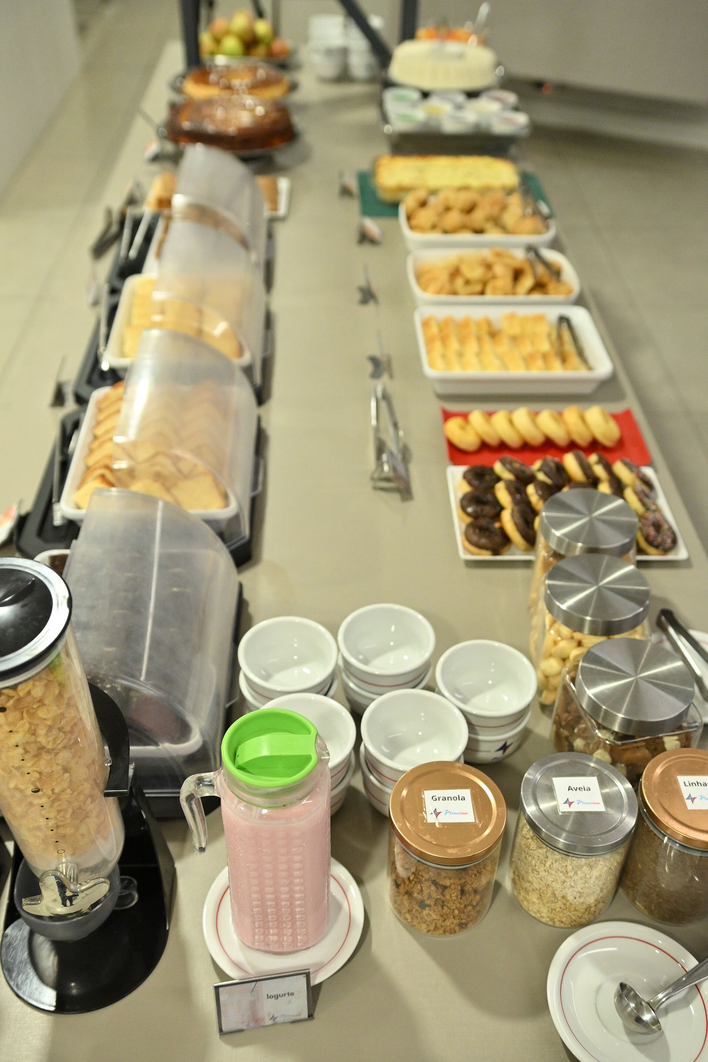A buffet with various food items and containers labeled with names like Granola and Avelia.