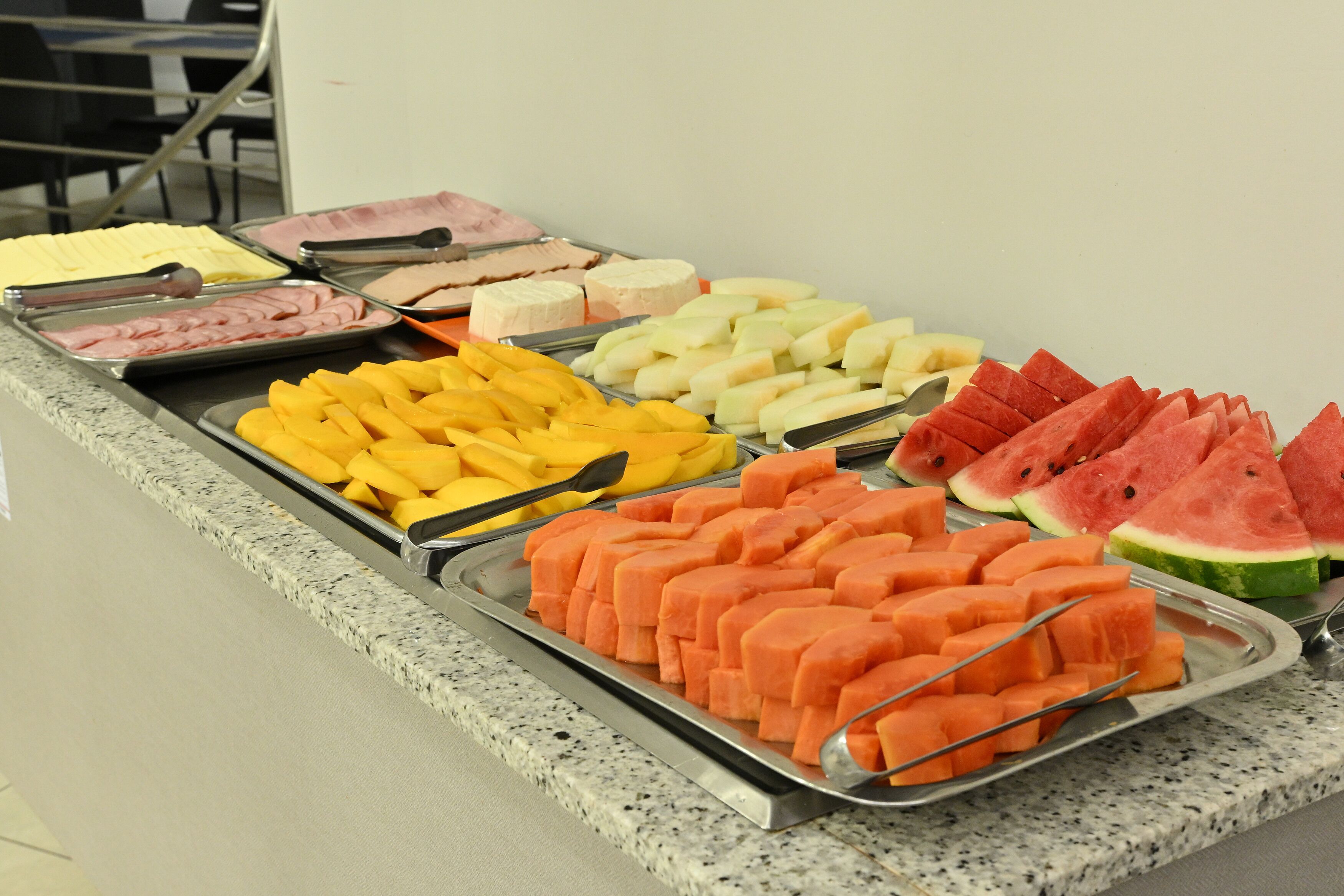 Un bufé con frutas y carnes variadas.