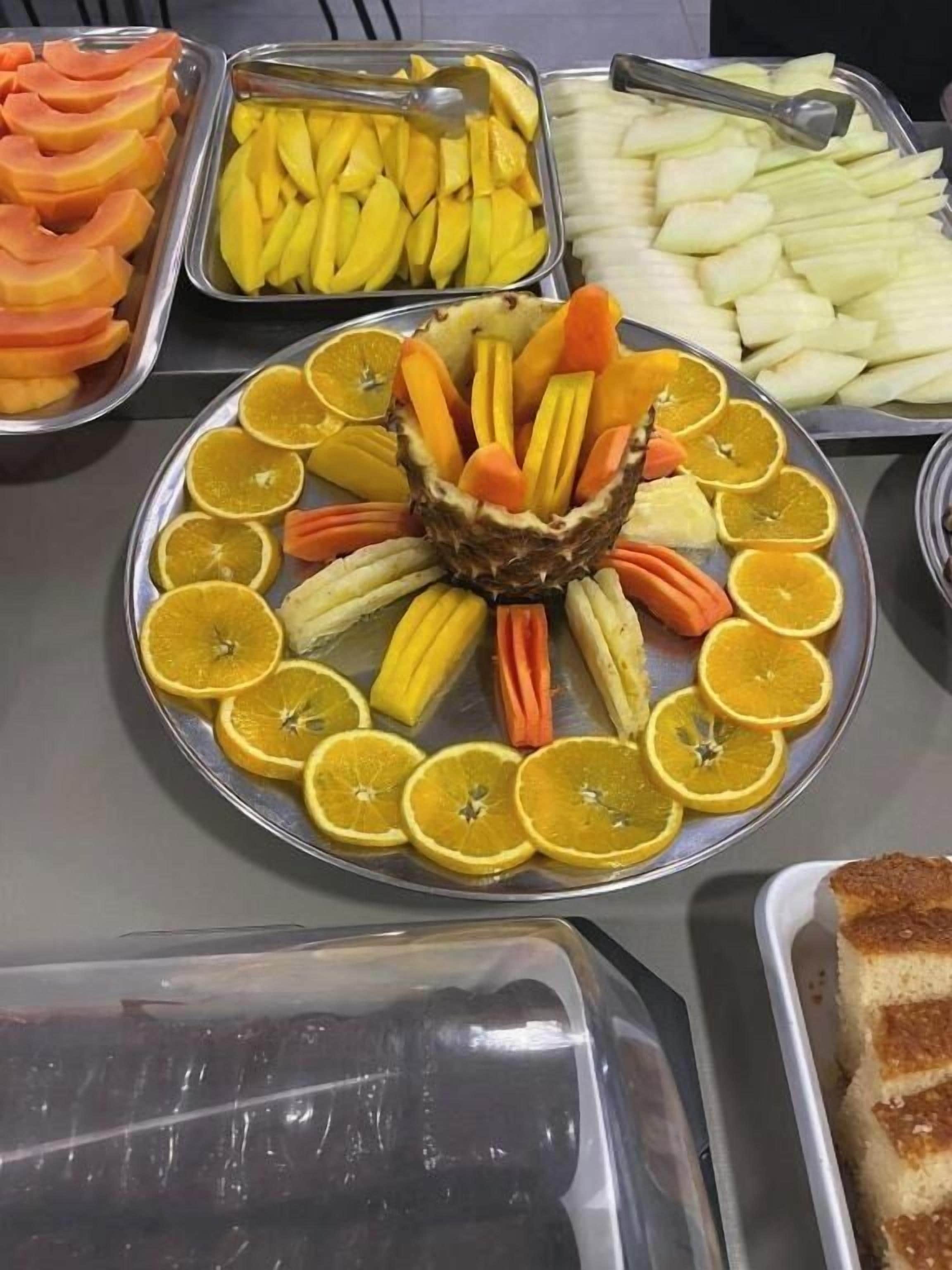 A buffet with various fruits and a central fruit arrangement.