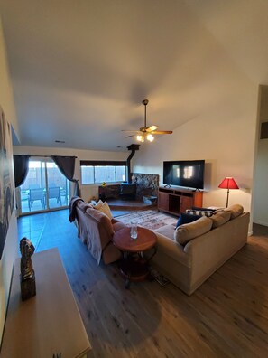Relax in this inviting living room with a fireplace, comfortable sofa, and large window.