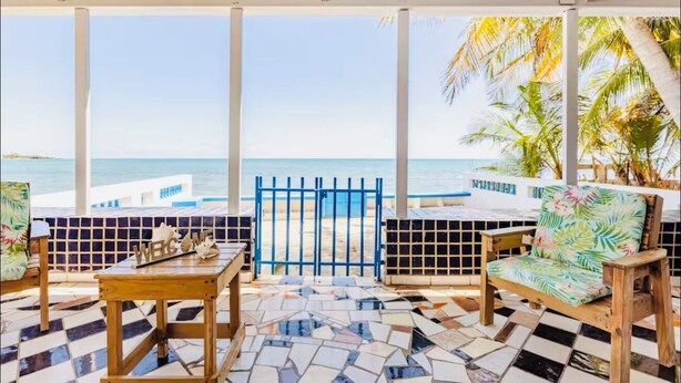 Un espace extérieur abrité, aménagé avec des sièges, et offrant une vue sur la plage et l’océan.