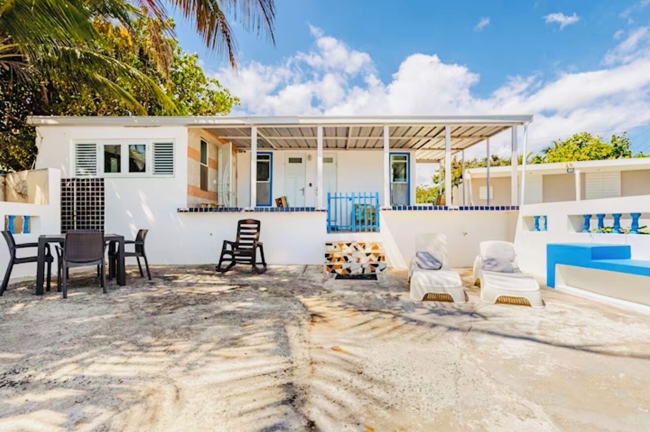 A beachside building with a covered patio, outdoor seating, and a small pool area.