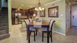 A spacious kitchen with dark wooden cabinets, a central island, and a dining area with a large table and chairs.