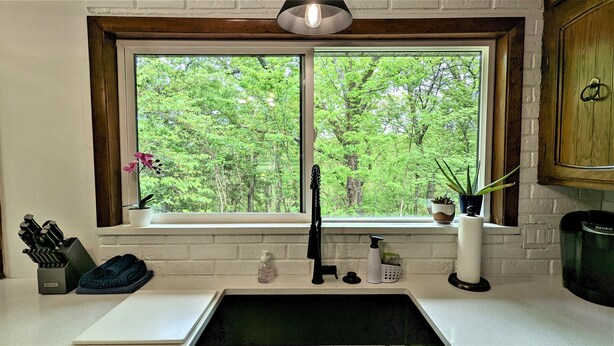 A kitchen with a window, sink, and various kitchen items. - An Updated, Secluded family friendly home with Fast Wifi (Manhattan)