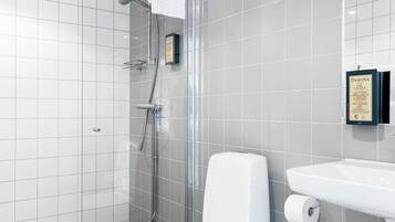 Een moderne badkamer met een douchecabine van glas, een wit toilet en een wastafel met spiegel erboven.