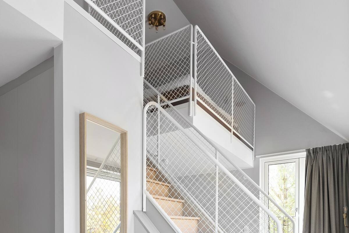 A staircase with white railings and a wooden finish, leading to an upper floor.