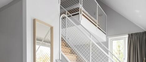 A staircase with white railings and a wooden finish, leading to an upper floor.