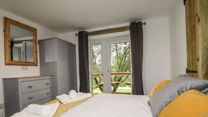 Una camera da letto con un letto, un armadio, uno specchio e una finestra con tende.