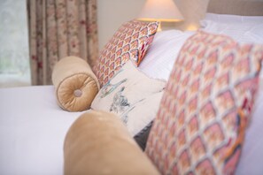 A bed with patterned pillows and a quilt.