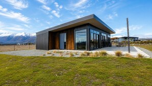 A modern building with a flat roof, large glass windows, and a wooden facade. - Black Box, Twizel, FREE WIFI (Twizel)
