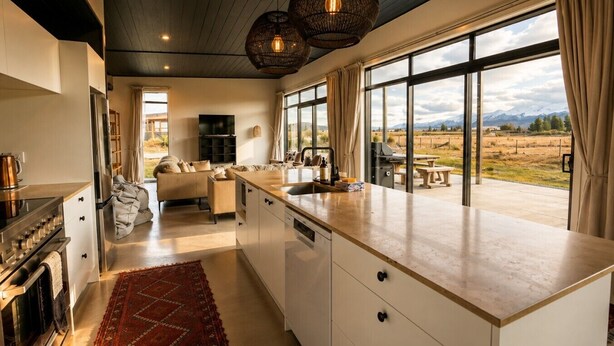 A modern kitchen with a large island, a dining area with a view, and a cozy living space. - Black Box, Twizel, FREE WIFI (Twizel)