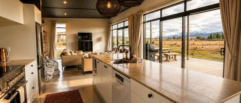 A modern kitchen with a large island, a dining area with a view, and a cozy living space.
