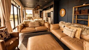 A modern living room with leather sofas, a dining area, and a kitchen. - Black Box, Twizel, FREE WIFI (Twizel)