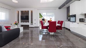 A modern kitchen with white cabinets, a built-in oven, and a microwave. - Villa Mia with pool in Garica (Garica)