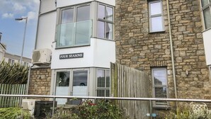 A two-story building with a sign reading "FOUR SEASONS". - The Hideaway (St Ives)