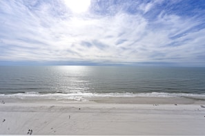 A beach with a wide sandy shore and gentle waves.