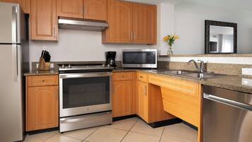 Una cocina moderna con electrodomésticos de acero inoxidable, armarios de madera y encimera de granito.