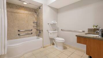 A bathroom with a bathtub, toilet, and sink.