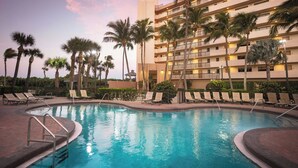 A hotel pool area with a large pool, lounge chairs, and palm trees. - Vistana Beach Club (Jensen Beach)