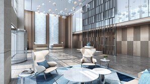 Eine moderne Lobby mit einer Sitzecke, einem Empfangsschalter und einem großen Fenster.