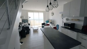 A modern kitchen with a central island, white cabinetry, and pendant lighting.