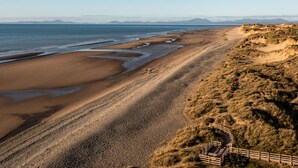 A coastal landscape with a sandy beach, pebbly shore, and dunes. - Bennar Fawr (Dyffryn Ardudwy)