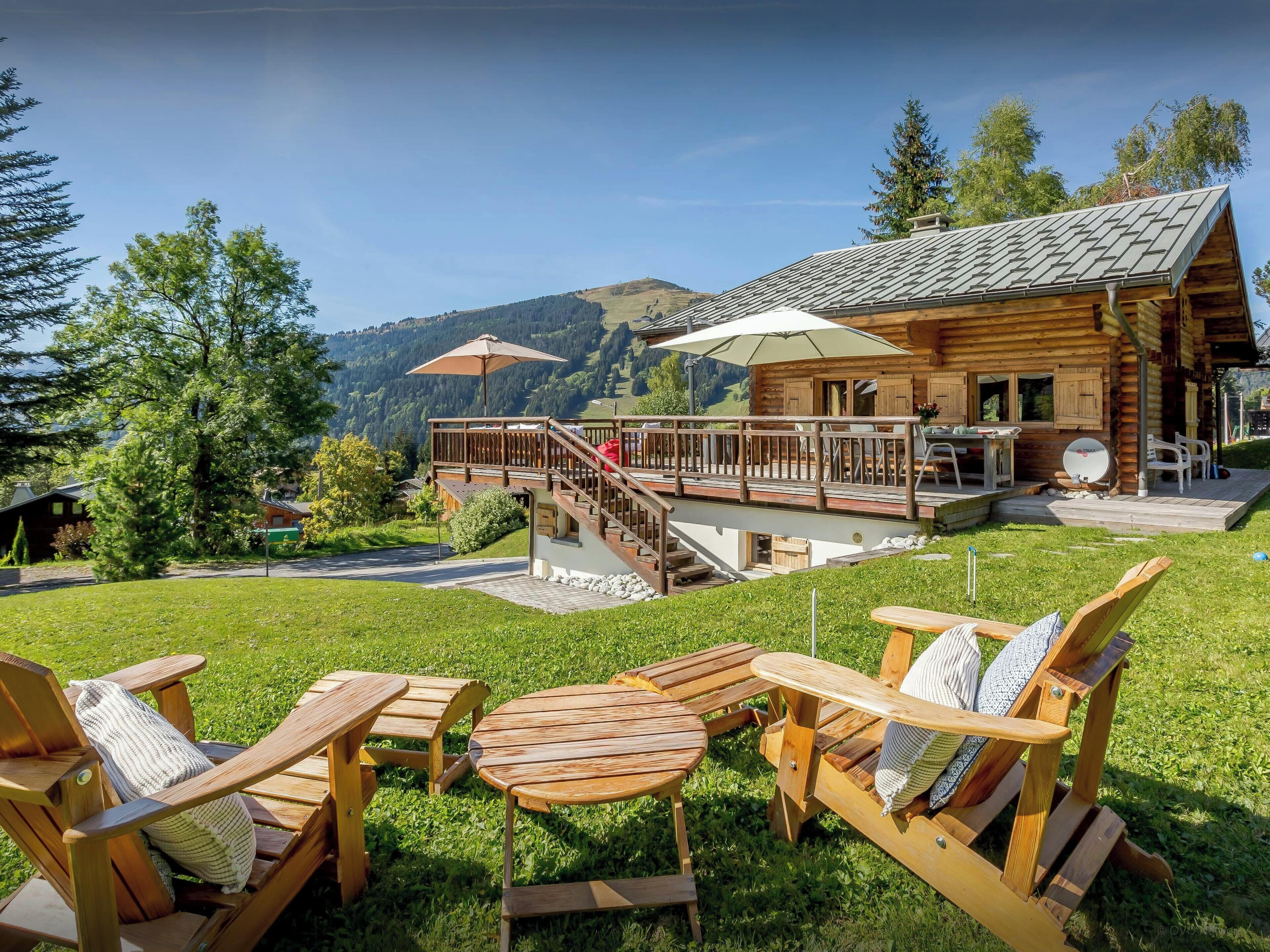 Eine Holzhütte mit Terrasse und Sitzbereich im Freien.