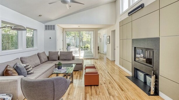Ein geräumiges Wohnzimmer mit einem großen Sofa, einem Couchtisch und einem Kamin.