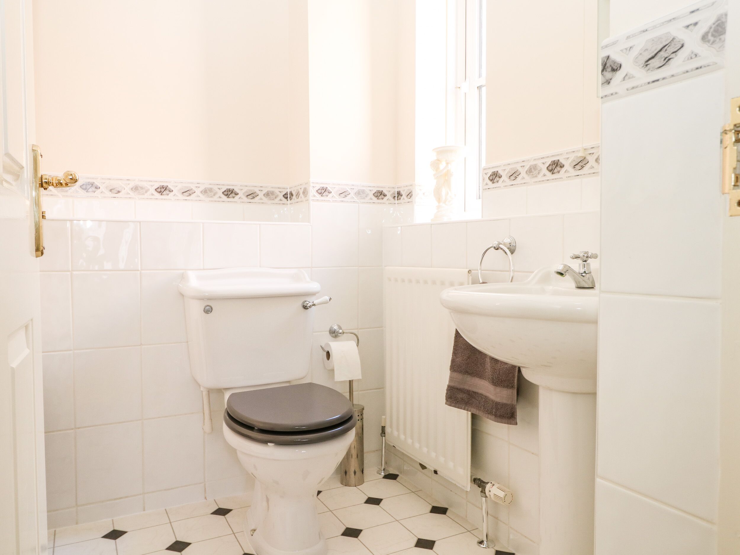 A small bathroom with a toilet, sink, and radiator.