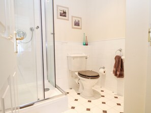 Une salle de bain avec une douche à parois de verre, des toilettes et un lavabo.