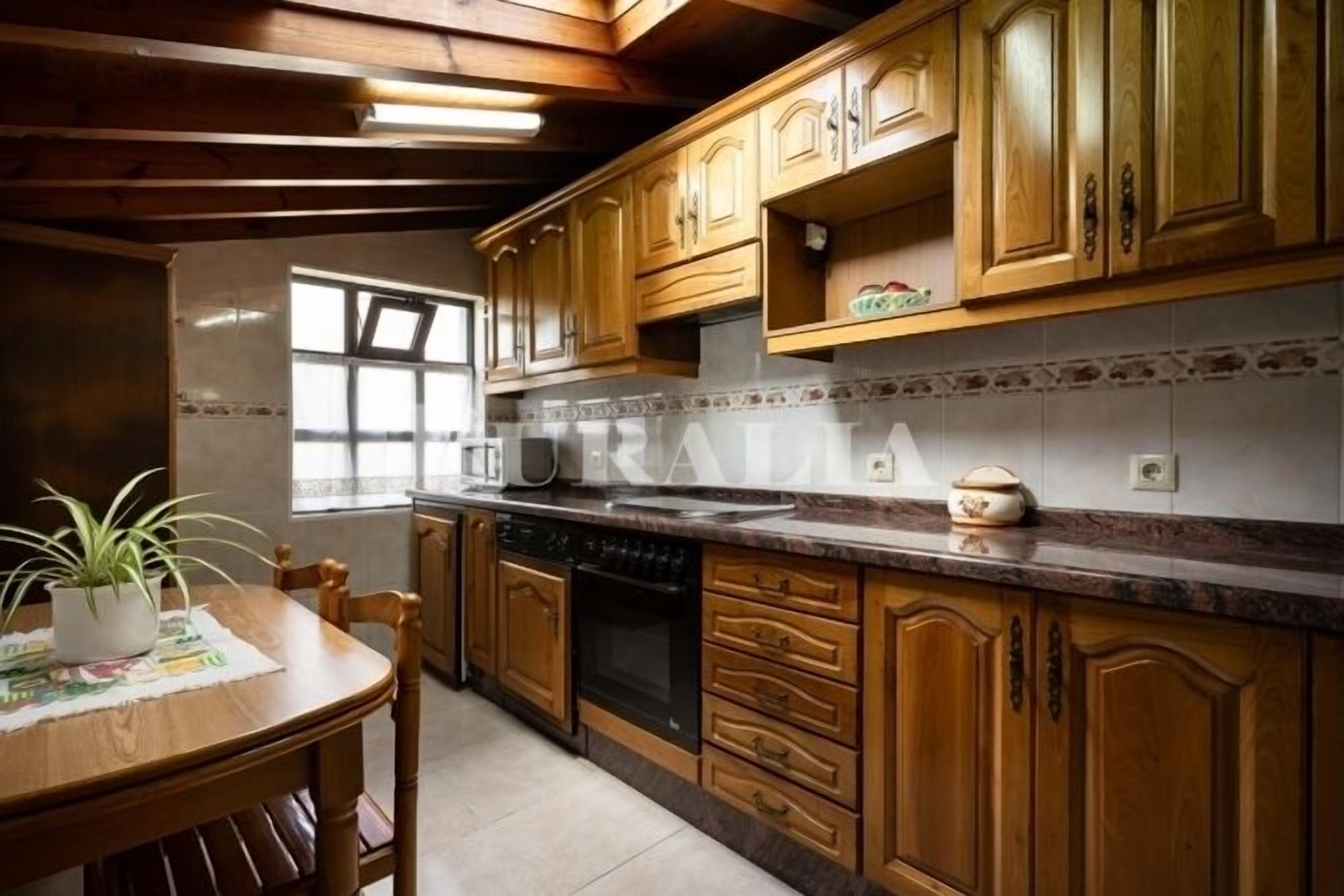 A kitchen with wooden cabinets, a granite countertop, and a window.