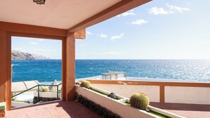 A balcony with a view of the sea, a table, and cacti. - Home2Book Relax Caletillas, Terrace & Pool (Las Caletillas)