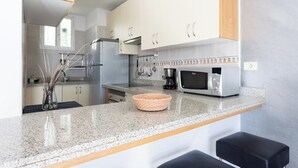 A modern kitchen with granite countertops, stainless steel appliances, and a built-in microwave. - Home2Book Relax Caletillas, Terrace & Pool (Las Caletillas)