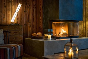 A cozy room with a fireplace, wooden walls, a cushioned bench, and a modern lamp. - FREIgeist Göttingen Nordstadt - A Member of Design Hotels™ (Goettingen)